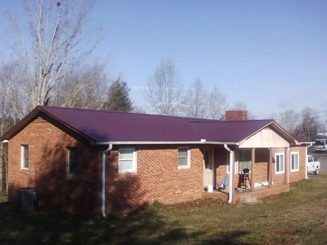 Burgundy metal roof on a brick ranch home with a new addition in Mineral Wells